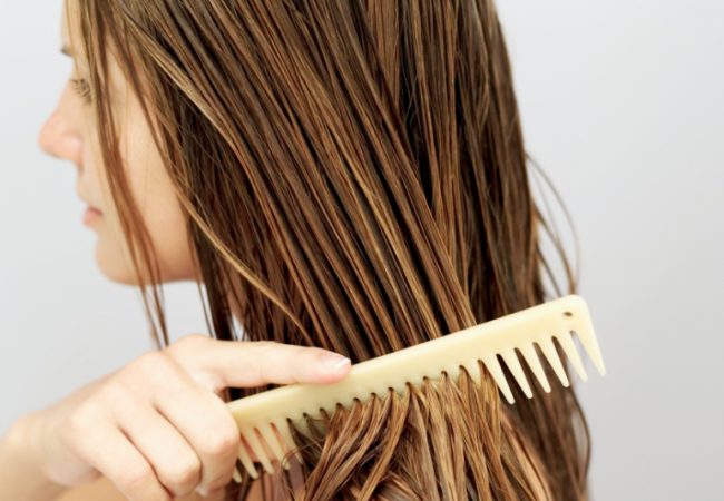 side view of a woman combing her hair